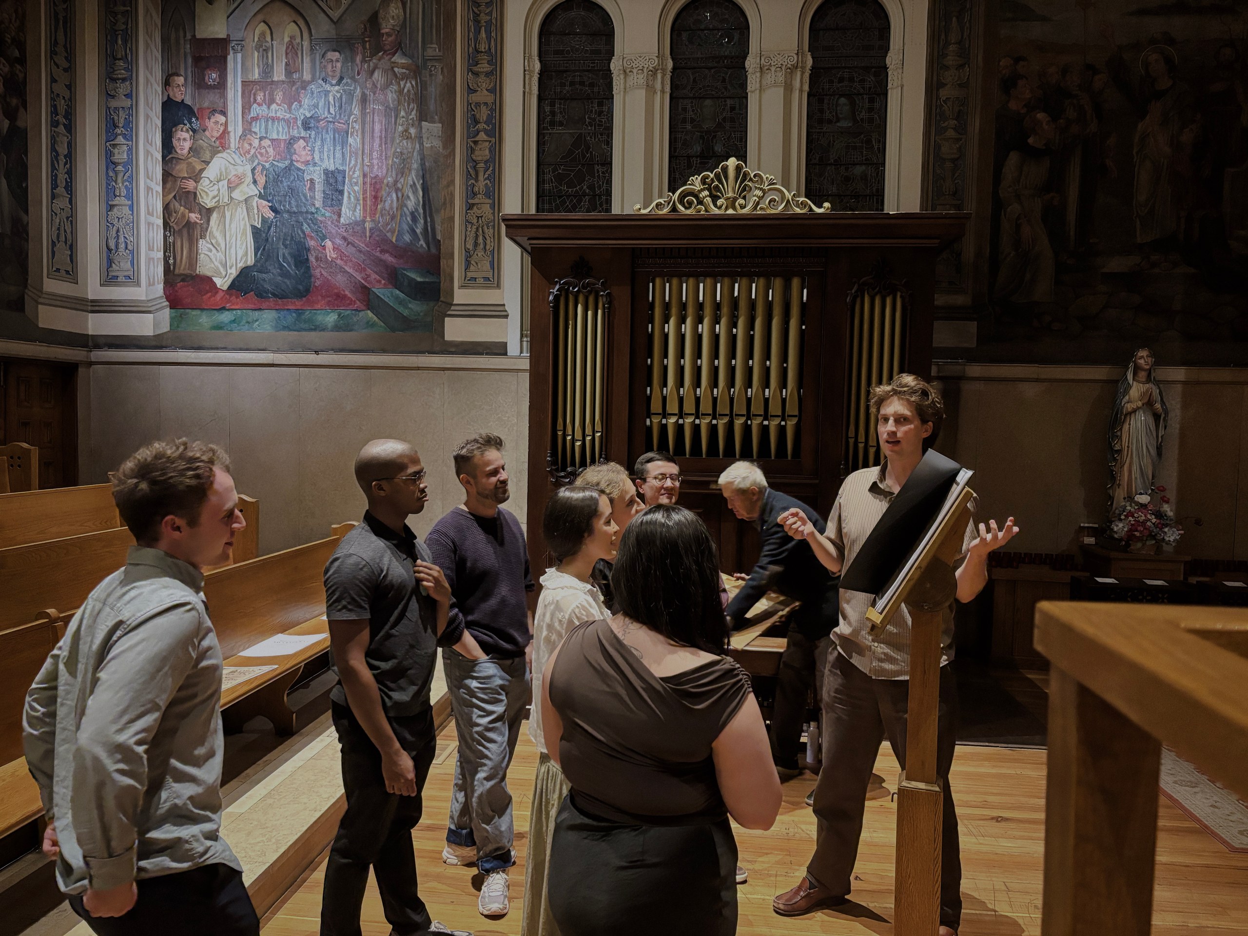 Willem Peek explaining at the lectern, with the singers and the organ of St. Paul’s Church