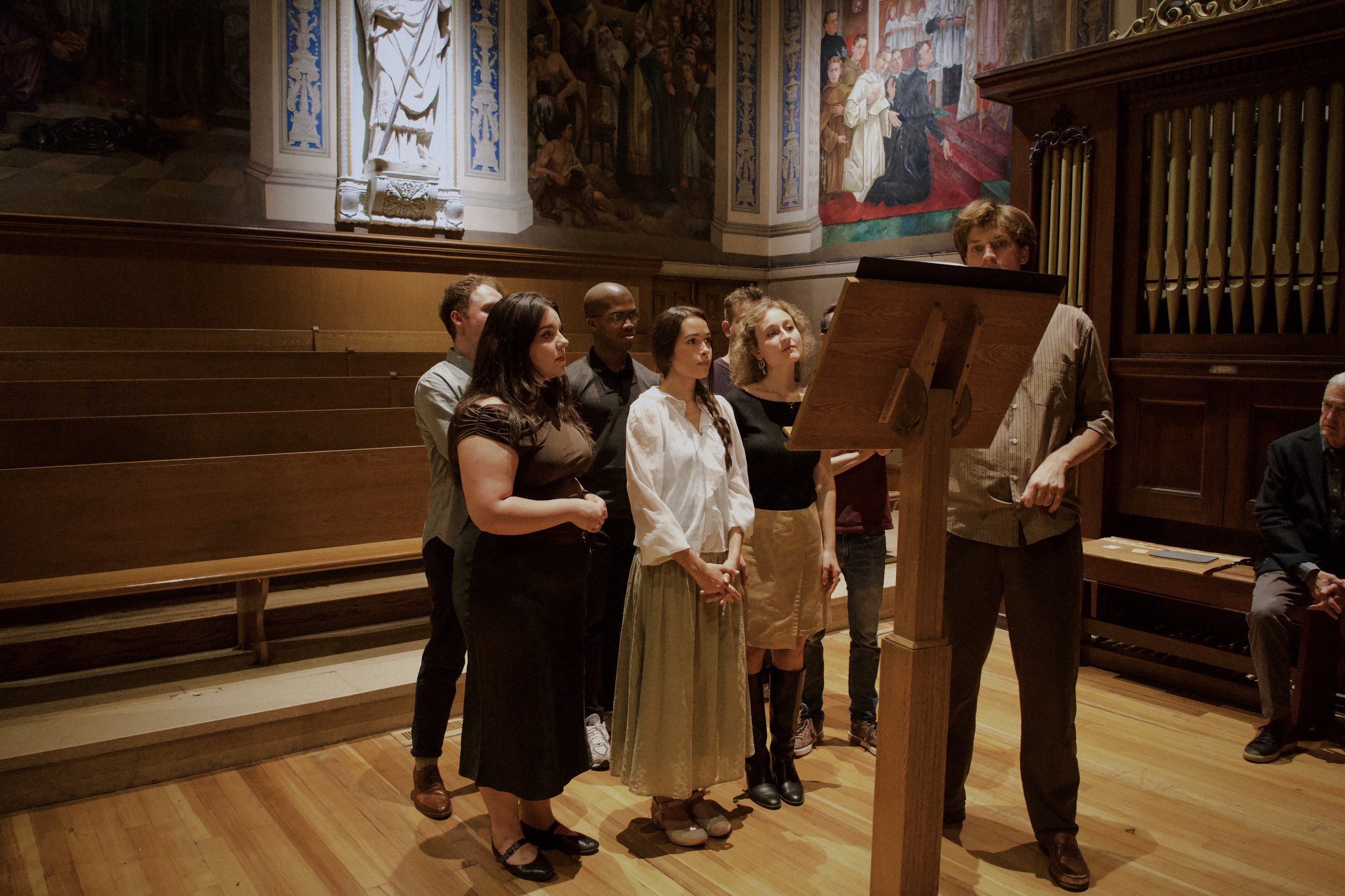 Singers of ὕδραυλις reading from the lectern at St. Paul’s Church, Harvard Square, at their rehearsal on 14 October 2026